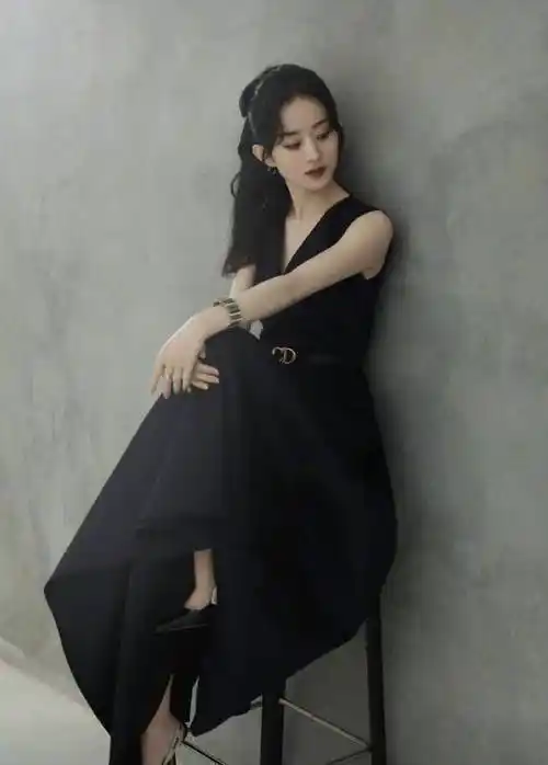 动态中的第一张是赵丽颖坐在椅子上的照片,她身穿宽吊带式黑色v领