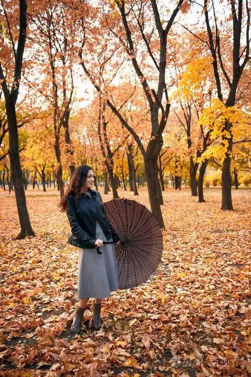 秋天公园里摆着伞的漂亮女人秋天的美丽景色