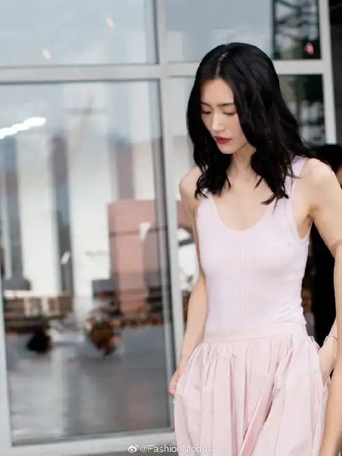 超模#刘雯#今日出席大秀造型,针织背心搭配伞裙,粉色系也能被她演绎得