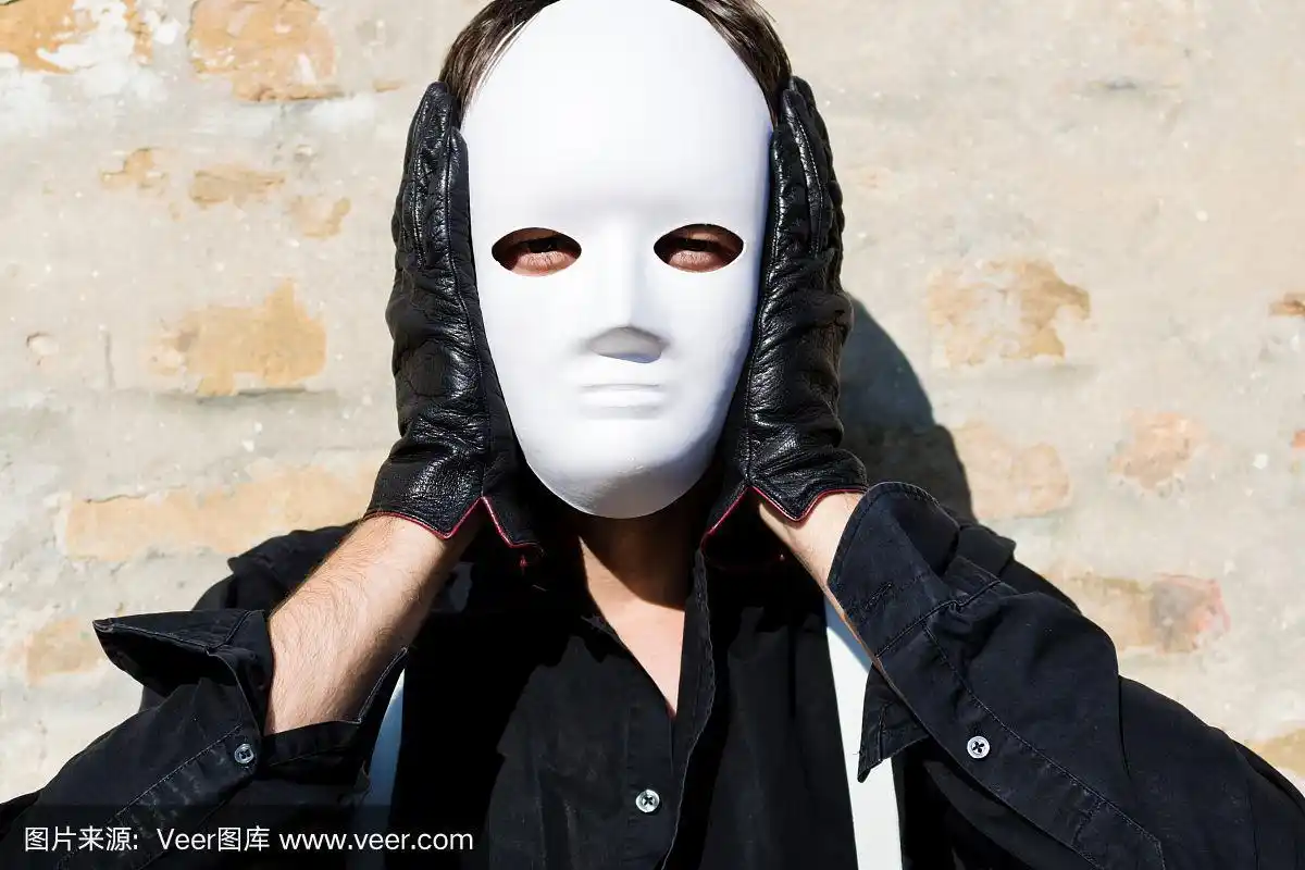 一名男子戴着白色面具,看着镜头.