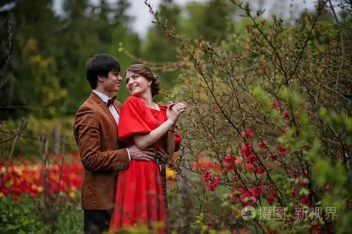 一对夫妇在花丛附近拥抱相爱. 时尚的男人照片-正版商用图片0es38v-摄