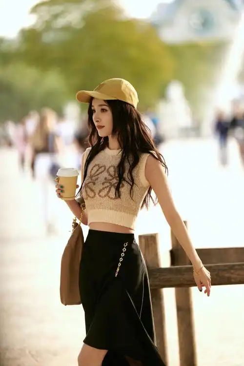 杨幂穿针织背心配黑色半身裙 长发配上棒球帽 休闲随性又不失魅力