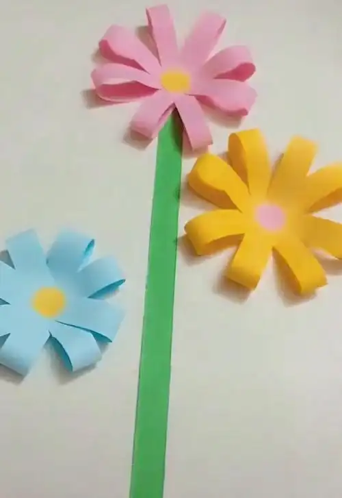 7,把花朵粘贴在卡纸上,粘贴位置可以上下一点,然后贴上绿色的花茎.