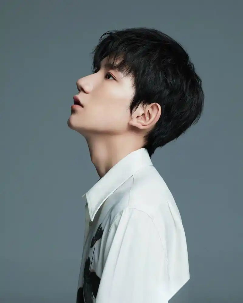 照片中王源随性坐在沙发一角直视镜头,眼神杀霸气十足