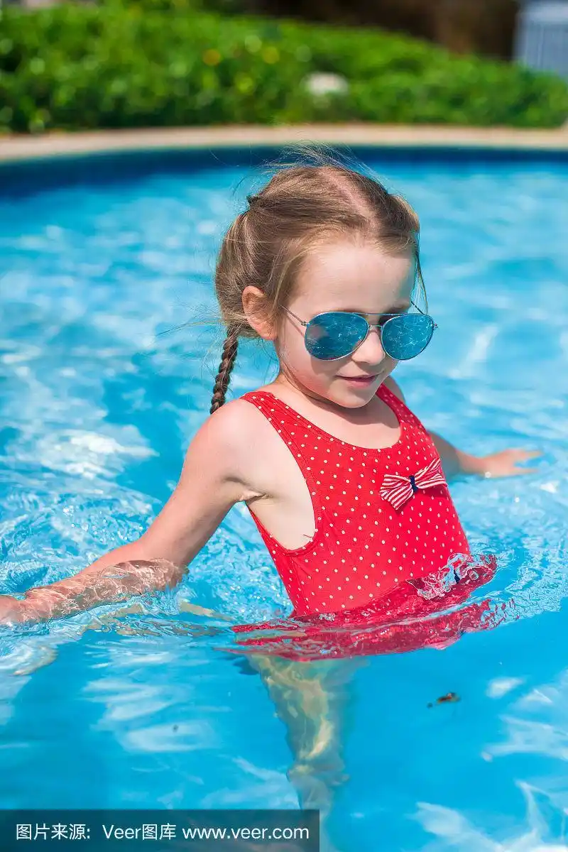 可爱的小女孩在游泳池里游泳