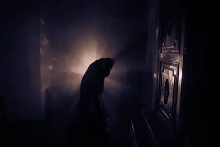 鬼魂在暗室里的恐怖剪影镜子可怕的万圣节概念剪影女巫在鬼屋内的背景