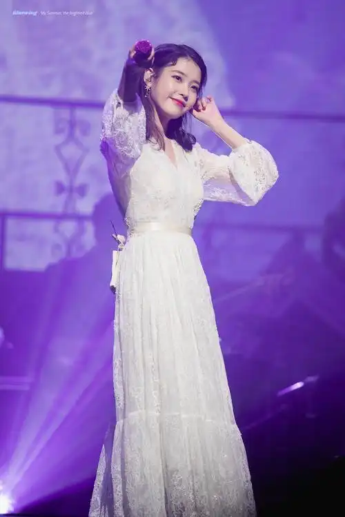 在舞台上唱歌的iu:身着白色纱裙显得亭亭玉立,光芒万丈.