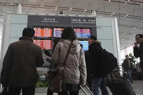 2月10日上午,旅客在首都机场候机大厅浏览航班信息.