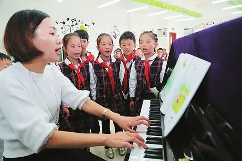 复兴小学音乐教室,孩子们在老师伴奏下唱歌.