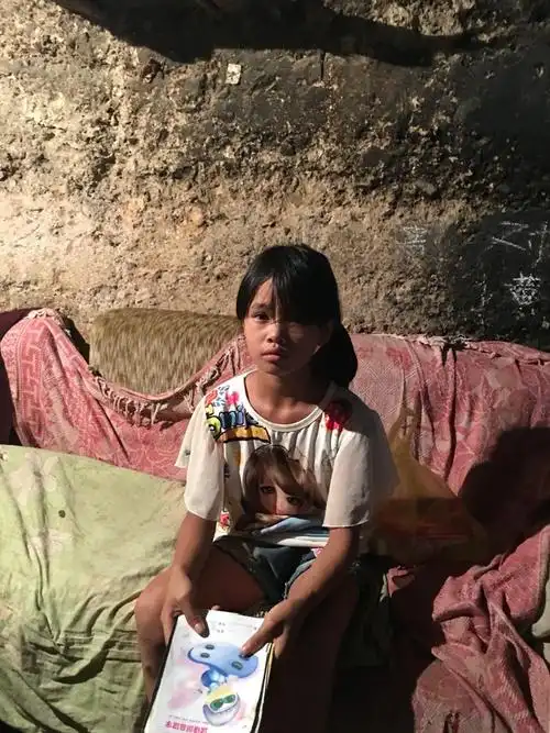 小访小问姐妹俩 小访拿起作业本,眼睛充满里有着早熟,生活压力的忧郁