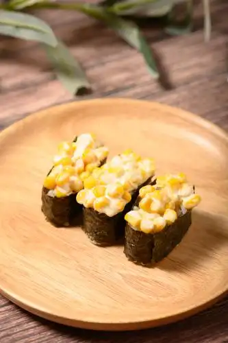 桌面上的盘子里的美味可口的玉米军舰寿司