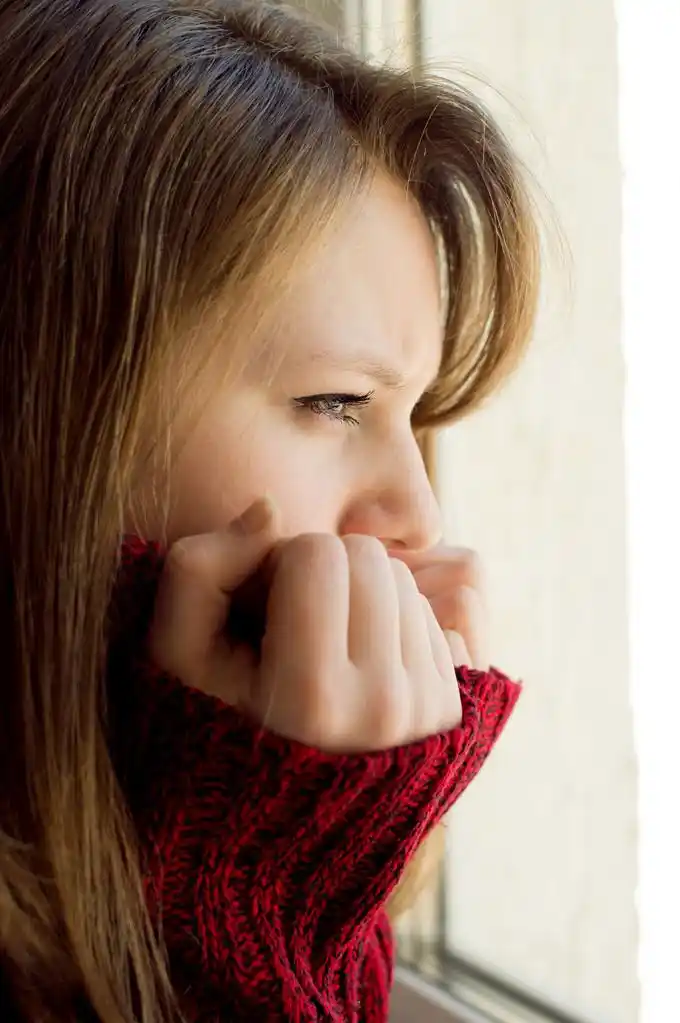 伤心的女孩望着窗外等待她的丈夫