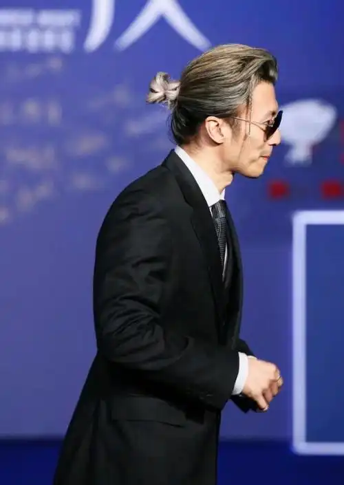 谢霆锋把留长的头发挑染成黑白金三色,并扎起低发髻兼将一撮刘海鬓