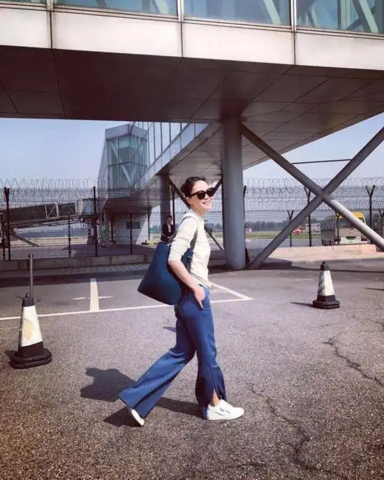 王菲现身机场低调赴巴黎看秀 蓝白配轻装露开怀大笑