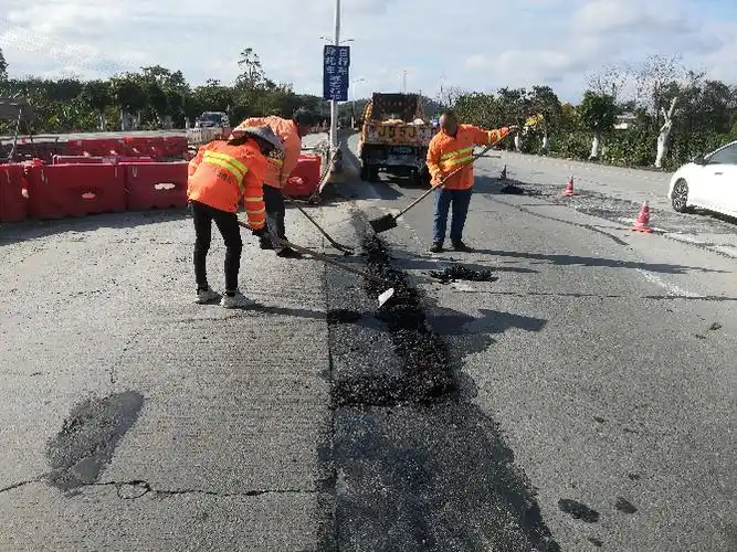 养护工抢抓晴好天气沥青修补国道连珠江2桥路段坑槽路面(恩平公路局