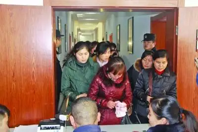 工人们正在排队领取自己被拖欠的工资.