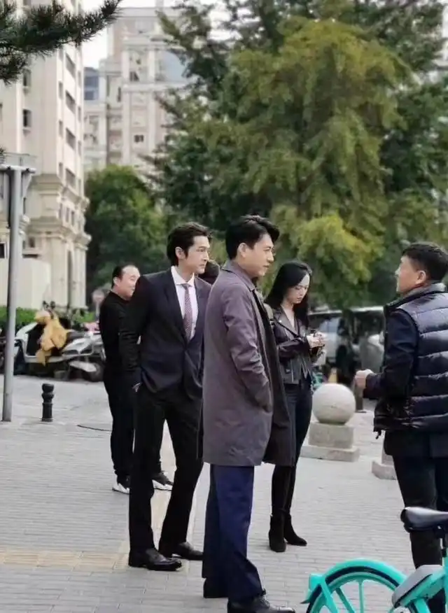 两人都是180cm还要多的身高,胡歌穿了一套黑西服,靳东则穿着棕色长款