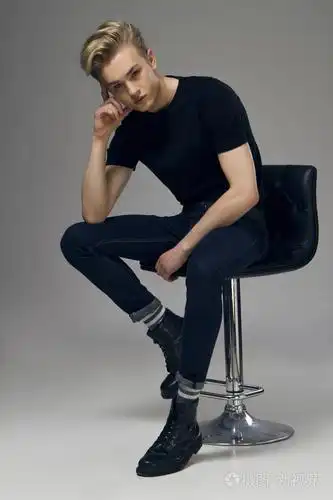 一个年轻的男模特,坐在椅子上的全长图片照片-正版商用图片0q0bkm-摄