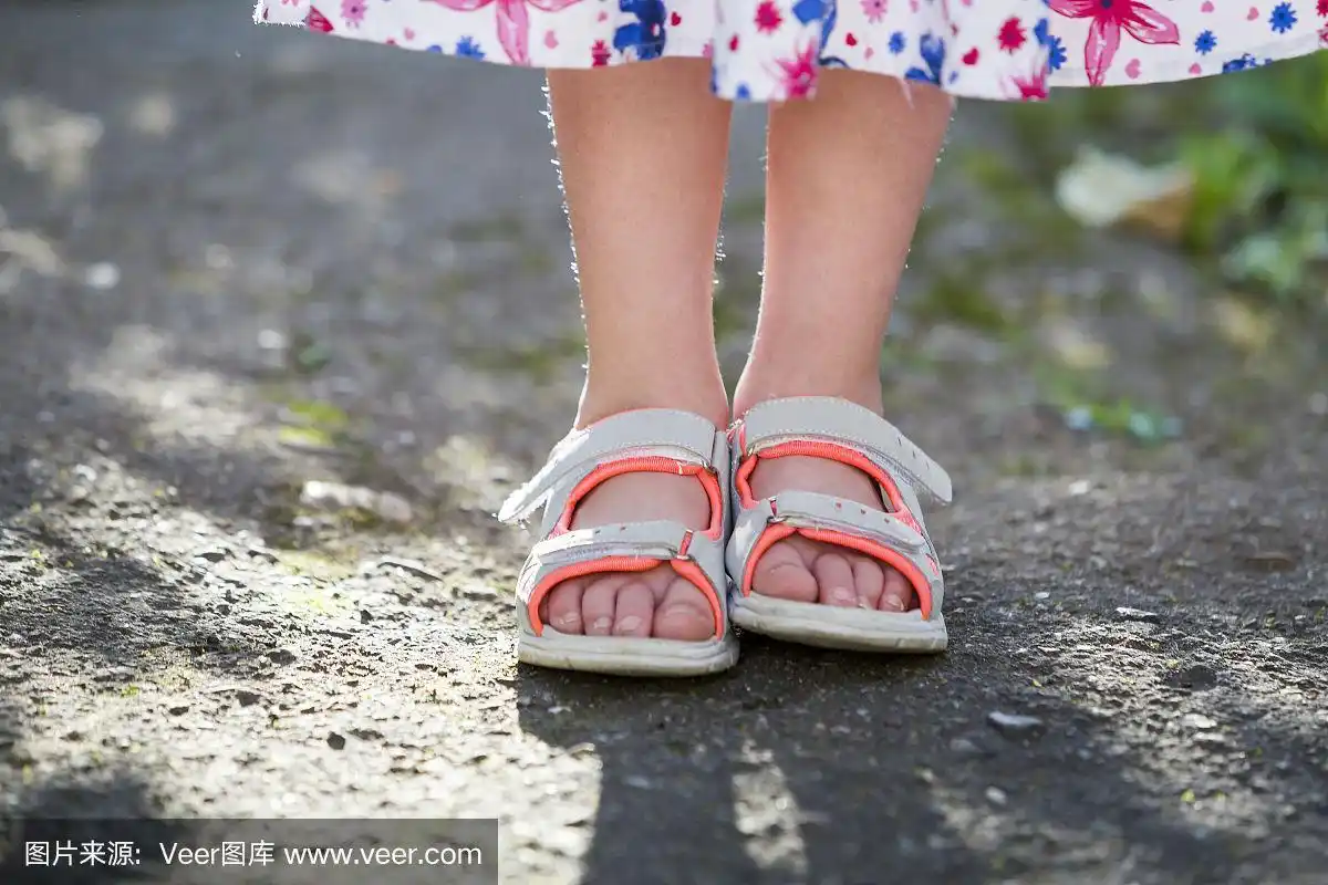 近距离的孩子女孩的脚穿夏天的凉鞋鞋