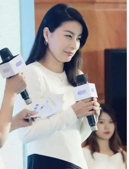 郭晶晶脸上只画了淡淡的妆容,耳朵上带着珍珠耳饰,拿着话筒正在说话