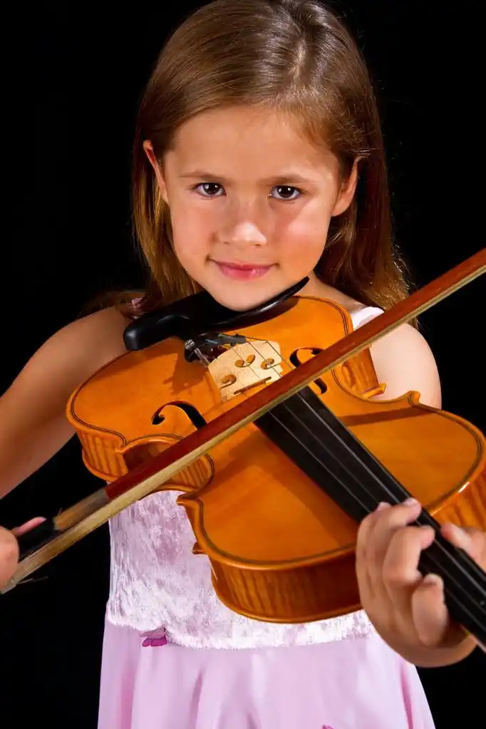 在粉红色的裙子拉小提琴的女孩