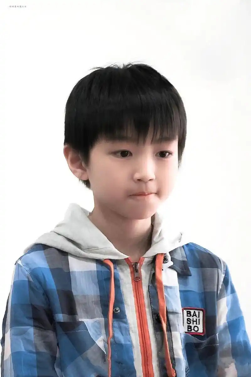 王俊凯小时候脸蛋儿嘟嘟的,头发像顶个小锅盖看着就像个可爱的小奶娃