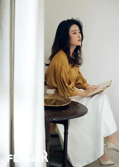 徐百慧身穿卡其色上衣搭配白色半身裙,脚踏银色高跟鞋,慵懒而不失优雅