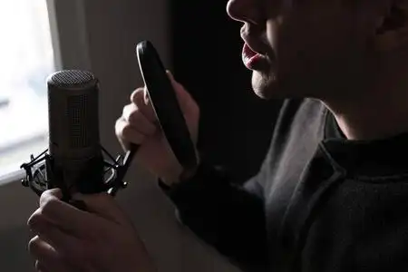 一个近距离的麦克风唱歌的年轻男人站在嘴唇照片