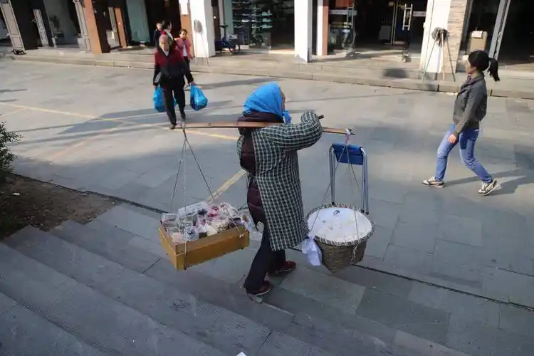 65岁的她白天挑扁担卖糖晚上做酒酿 不给儿子添负担