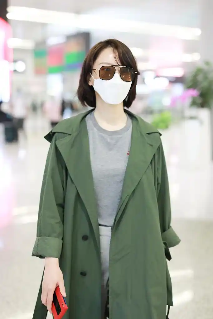 陈数穿绿色风衣现身机场 走路带风短发飞扬