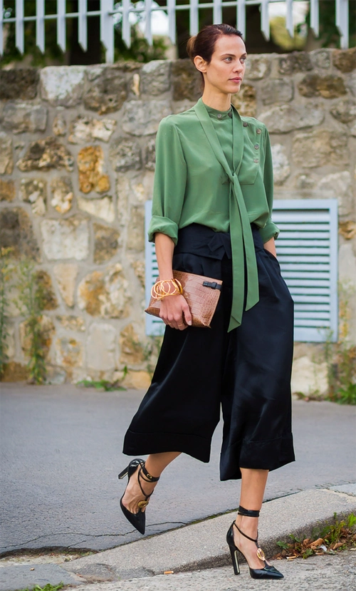 草木绿的垂坠上衣搭配黑色稳重的阔腿裤,扎进裤子凸显女性的曲线,加上