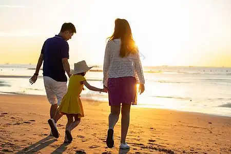 夕阳下一家三口在海边玩耍图片素材