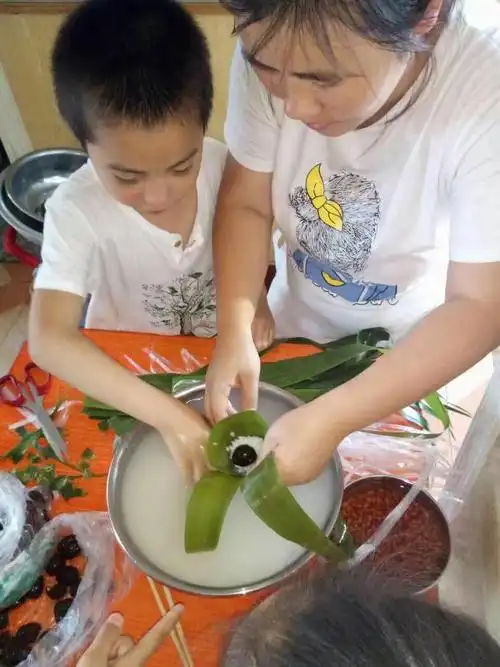 7月26日,中午宝贝儿子在跟妈妈在家学包粽子,包的手忙脚乱的,儿子说