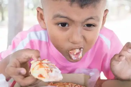 可爱的亚洲小男孩吃零食照片