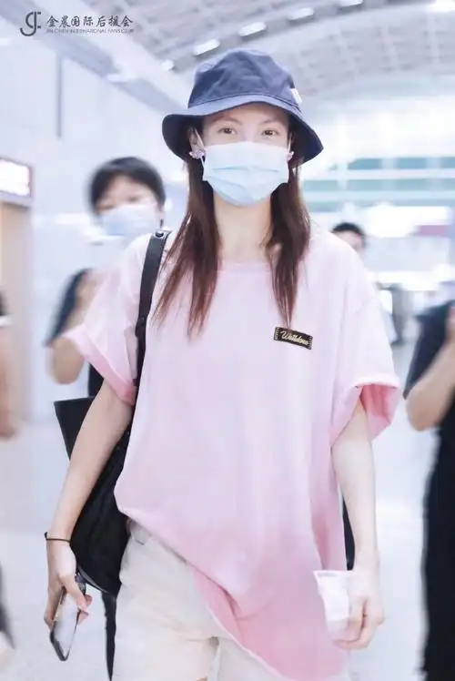 金晨今日机场照更新,粉色宽松短袖搭配休闲短裤,肩挎倒三角logo黑色