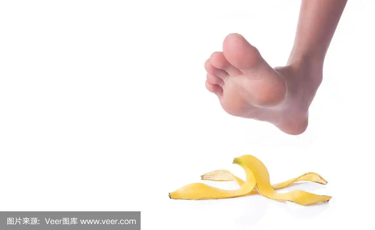 一个人的光脚踩在白色的背景上的香蕉