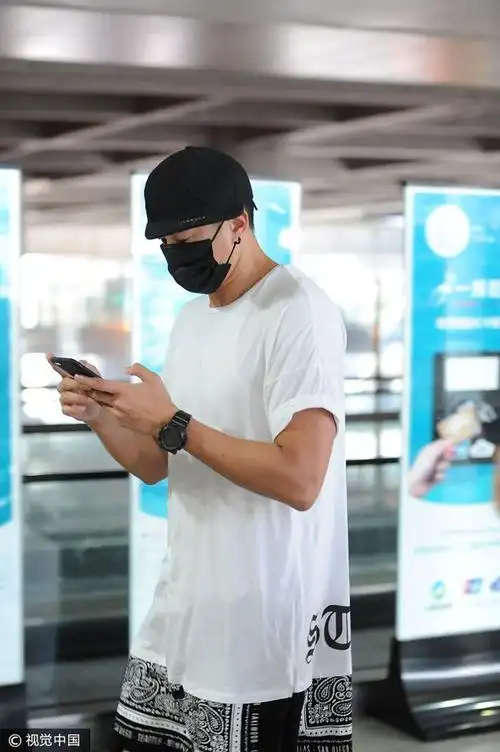 吴聘哥哥又上线啦何润东潮装现身机场不断玩手机似与娇妻传情