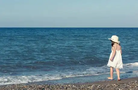 大海独自一人白色礼服走大海独自一人在海边玩耍的小女孩照片