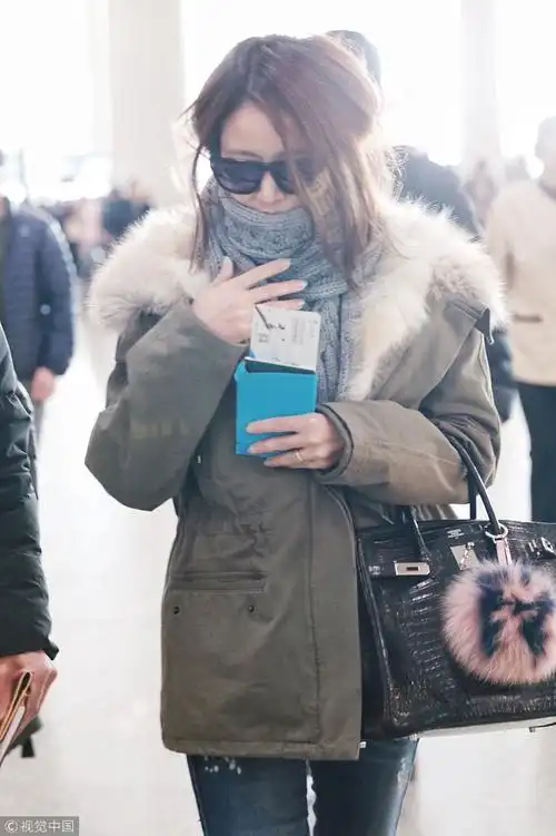 林心如现身机场见镜头亲切挥手秀钻戒