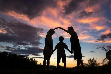 汽车夕阳摄影照片_夕阳下幸福的一家三口手牵手