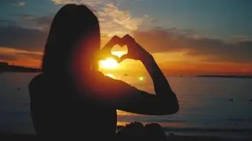 女孩比心夕阳剪影金色阳光视频素材