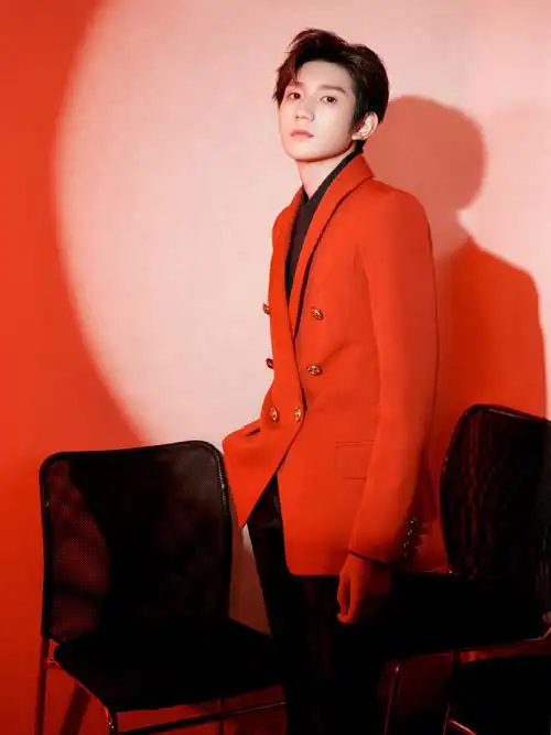 照片中,王源身穿红色西装搭配黑色衬衫,帅气十足.