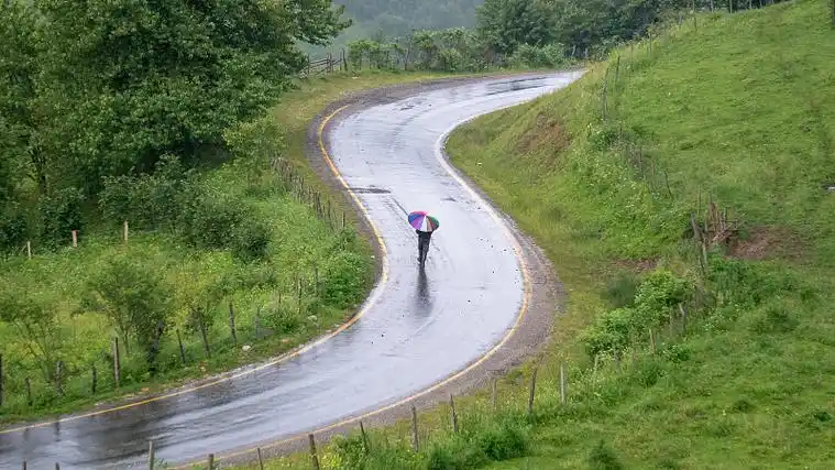 土耳其,一名男子撑着一把彩色雨伞走在雨中图片下载