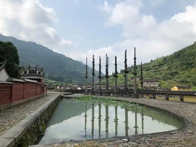 德远堂前有一口半月形的池塘,两侧石坪上耸立着23根石龙旗杆