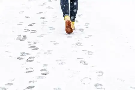 下雪走路冬天穿黄色皮靴走路.
