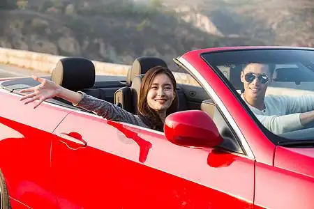 盘山公路秋天跑车青年男女开车出去旅行图片素材
