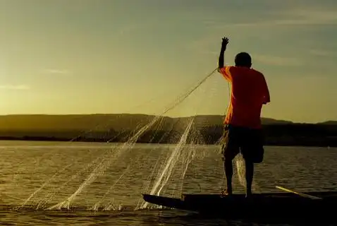 在湄公河流域的人们捕鱼和日落.泰国