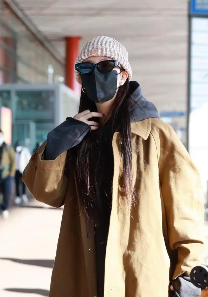 宋妍霏机场街拍,棕褐色风衣 连帽卫衣 毛线帽这样穿让时髦毫不费力