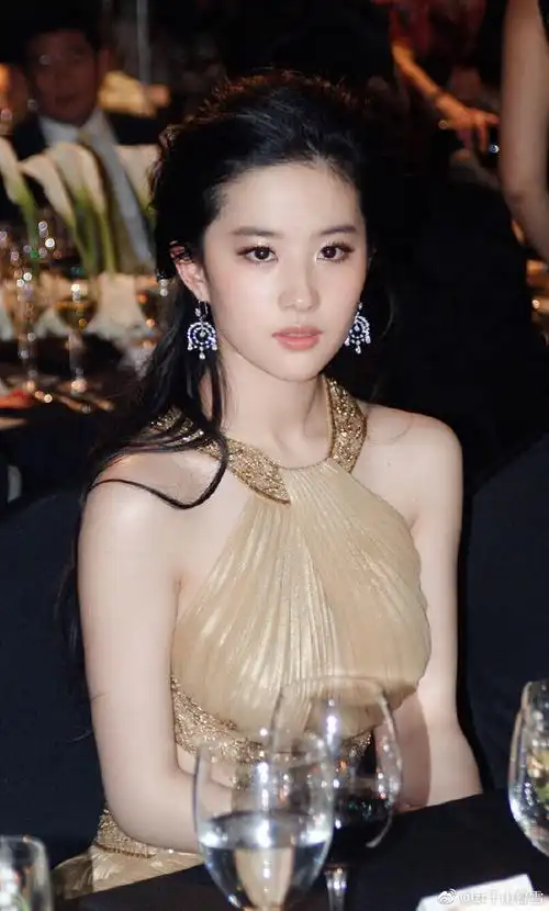 2010年4月28日,上海,时尚芭莎慈善晚宴,刘亦菲一袭金色修身礼服出席