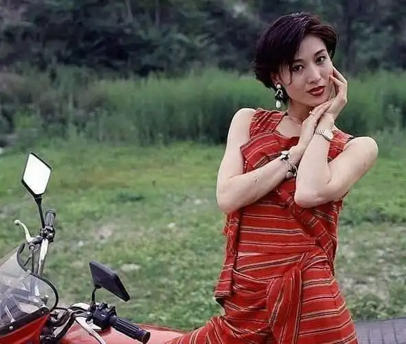 罕见95年中国女性老照片,一个美女坐在90年代的摩托车上面,姿势罚常